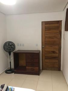 um quarto com uma porta de madeira e uma ventoinha em Suite Duplo Wind Jeri em Jericoacoara