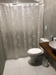 a bathroom with a toilet and a shower curtain at Suite Economica Wind Jeri in Jericoacoara