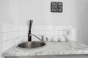 a kitchen counter with a sink and a sign on the wall at Luxury Hackney Apartment 10 mins to Liverpool Street in London
