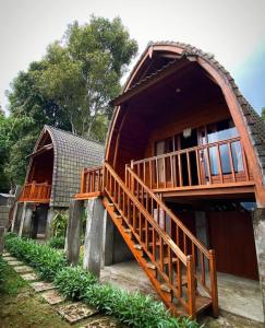 a house with a wooden staircase leading up to it at La Cascata Bali Munduk in Munduk