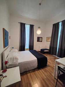 Schlafzimmer mit einem Bett, einem Schreibtisch und einem Fenster in der Unterkunft Rome Center Rooms in Rom
