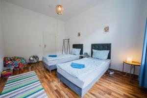 a living room with two beds and a rug at Blue Chili 04 - MD Top City Apartment - WiFi in Magdeburg