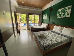 1 Schlafzimmer mit 2 Betten und einer grünen Wand in der Unterkunft TEZA Resort in Bantayan