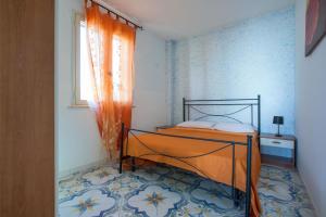トッレ・パリにあるCasa Dalilaのベッドルーム1室(オレンジ色のカーテンと窓付きのベッド1台付)