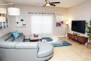 a living room with a couch and a flat screen tv at Candy Palm 8885 Water View Townhouse, Sleeps 12 in Kissimmee