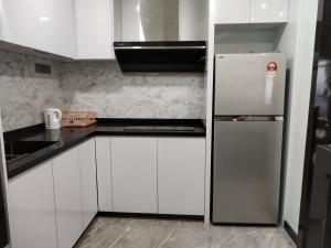 クアラルンプールにあるBintang Sky Villa Suites Times Square KLの白いキャビネットと冷蔵庫のあるキッチン