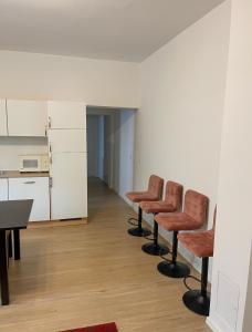 a room with three chairs and a table and a kitchen at 70qm Apartment für sie und ihre Familie 