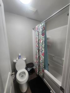 a bathroom with a toilet and a shower curtain at Prestige Guest Room London Ontario in London
