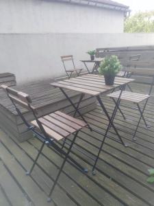 2 chaises et une table avec une plante en pot sur une terrasse dans l'établissement Séjour chaleureux, à Aubervilliers