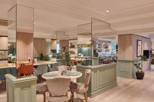 a living room with a table and chairs at Melia White House Hotel in London