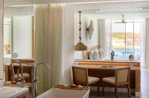 a kitchen with a table and chairs and a window at Meliá Cala Galdana in Cala Galdana