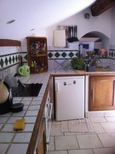 eine Küche mit einem weißen Kühlschrank und Fliesenboden in der Unterkunft 0170 m de la plage in La Ciotat