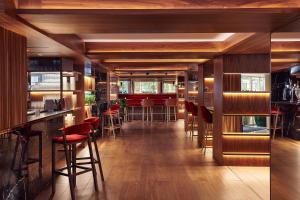 a bar with red stools in a restaurant at Melia White House Hotel in London