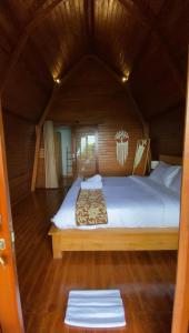 ein Schlafzimmer mit einem großen Bett in einem Zimmer in der Unterkunft La Cascata Bali Munduk in Munduk