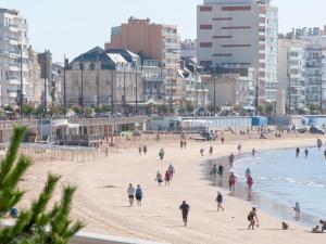 レ・サ​​ーブル・ドロンヌにあるAppartement Les Sables-d'Olonne, 1 pièce, 2 personnes - FR-1-92-760の海岸を歩く人々