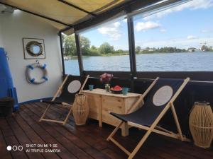 2 Stühle und ein Tisch auf der Rückseite eines Bootes in der Unterkunft Houseboat GDY-50, dom na wodzie z sauną i jacuzzi in Puck