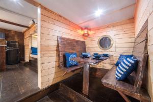 Habitación de madera con mesa y almohadas azules en Houseboat GDY-50, dom na wodzie z sauną i jacuzzi en Puck