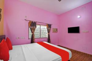 コルカタにあるHotel Salt Lake Palace Kolkata Sector II Near Dum Dum Park - Fully Air Conditioned and Spacious Room - Couple Friendlyのピンクのベッドルーム(ベッド1台、テレビ付)