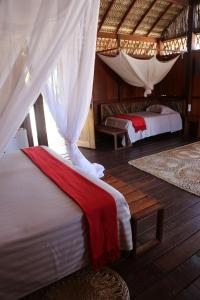 1 dormitorio con 2 camas y dosel en Vila Guará en Atins