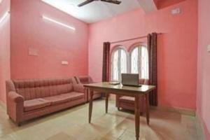 コルカタにあるHotel Salt Lake Palace Kolkata Sector II Near Dum Dum Park - Fully Air Conditioned and Spacious Room - Couple Friendlyのリビングルーム(ソファ、ノートパソコン付きテーブル付)