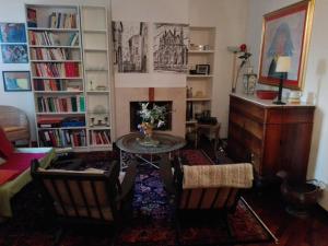 a living room with a table and chairs and bookshelves at Delizioso appartamento centrale in Perugia