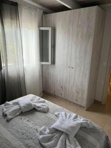 Kynopiástai的住宿－g&z cottage，一间卧室配有一张带白色床单的床和橱柜。