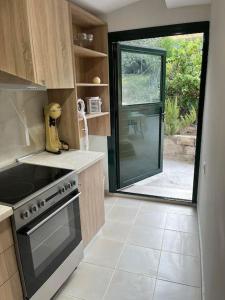 a kitchen with a stove and a large window at g&z cottage in Kynopiástai