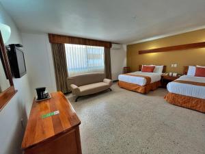 um quarto de hotel com duas camas e uma cadeira em Best Western Riviera Tuxpan em Tuxpan de Rodríguez Cano