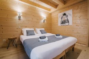 a bedroom with a large bed in a wooden cabin at The Alpine Lodge in Les Gets