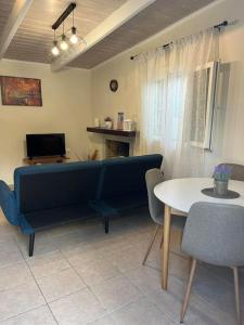 ein Wohnzimmer mit einem blauen Sofa und einem Tisch in der Unterkunft g&z cottage in Kynopiástai