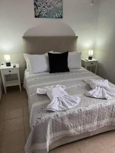 1 dormitorio con 1 cama con toallas en g&z cottage en Kynopiástai