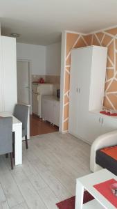 a living room with a table and a kitchen at Apartmani Borko 1-2 in Loznica