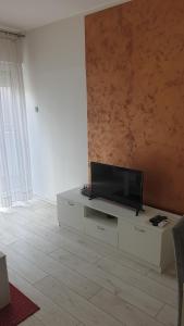 uma sala de estar com uma televisão de ecrã plano num armário branco em Apartmani Borko 1-2 em Loznica