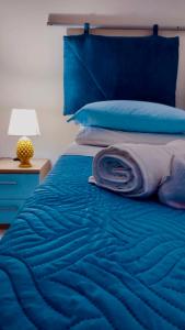 un letto blu con una coperta blu e una lampada di DGS APARTHOTEL a Trapani