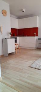 a kitchen with white cabinets and a wooden floor at Apartament Centrum przy Parku Zdrojowym in Nałęczów +10 photos