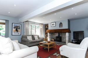 a living room with white furniture and a fireplace at Robin Cottage in Chipping Campden