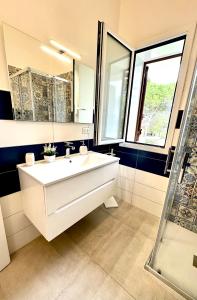 bagno con lavandino bianco e specchio di Villa Cavagrande ad Avola