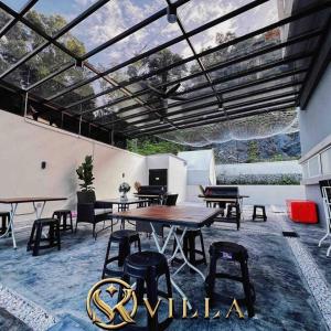 a patio with a wooden table and chairs and a roof at SKVilla private pool+ktv+bbq+starview up to 35pax in Ayer Keroh