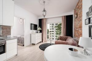 cocina blanca y sala de estar con mesa blanca en Apartment 66, en Gdansk