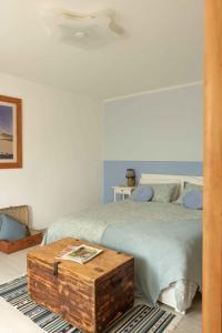 a bedroom with a bed with a wooden trunk next to it at VITEDIMARE APARTMENT SABBIA - SAND in Muggia