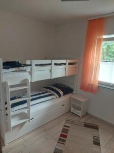 a bedroom with two bunk beds and a window at Ferienhaus Kleine Auszeit in Creuzburg