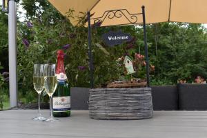 a bottle of wine and a glass on a table at Ferienhaus Kleine Auszeit in Creuzburg