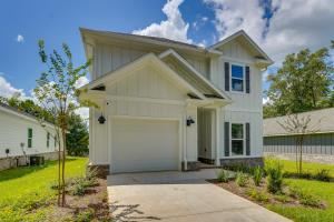 a white house with a garage at Spacious Freeport Home with Deck and 2 Living Areas! in Freeport
