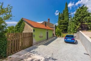 a house with a car parked in the driveway at Greenhouse Adria in Bribir