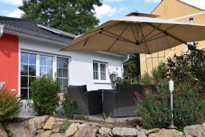 an umbrella and chairs in front of a house at Ferienhaus Kleine Auszeit in Creuzburg