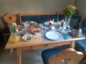 una mesa de madera con platos de comida. en Zu Hause am Bach, en Aggsbach