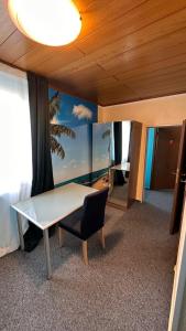 Bartels Stadt-Hotel في فيرل: طاولة وكرسي في غرفة مع نافذة