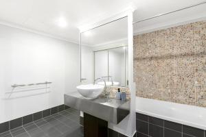 a bathroom with a sink and a mirror at The Palms at Mango Lagoon - Palm Cove Wellness Haven in Palm Cove