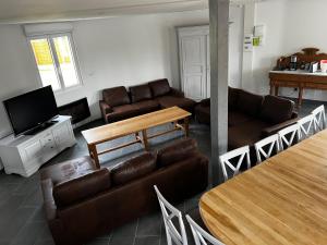 Bresles的住宿－Le château d’eau，客厅配有真皮沙发和电视