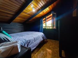Palmares的住宿－Cabañas San Rafael，一间带床的卧室,位于带窗户的房间内